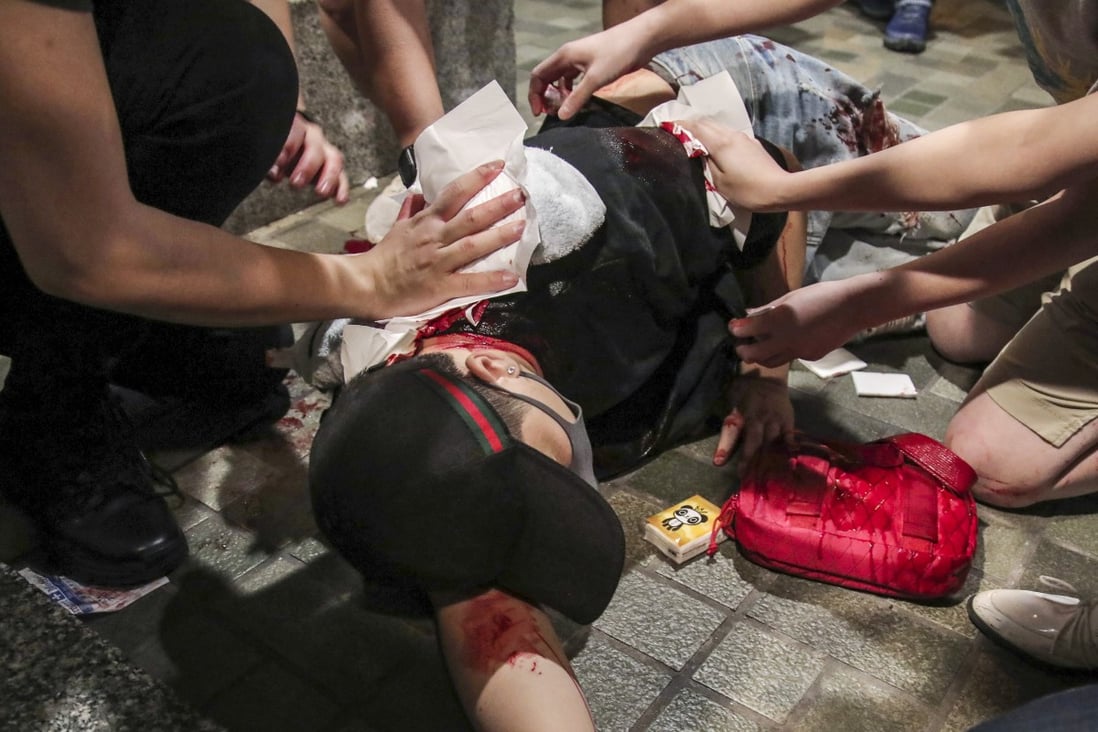 Passers-by attend to an injured man in a bloody mall altercation in 2019, while Hong Kong was in the throes of a social unrest. Photo: Handout