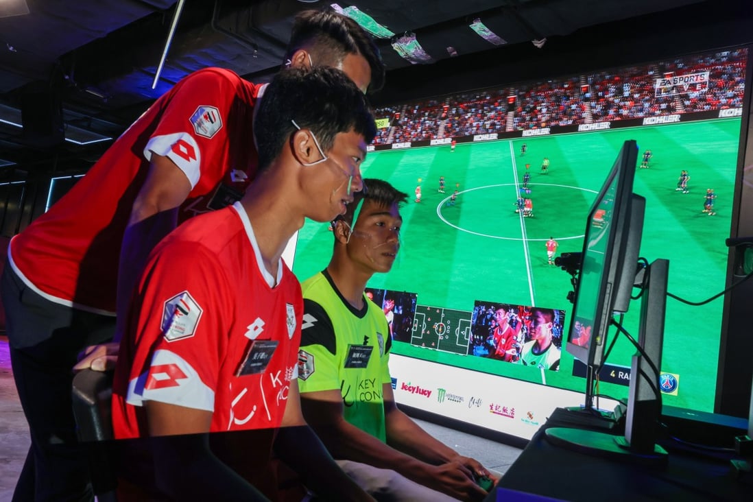 Ng Tsz-chung (front), Ngan Ngo-tin and Wong Wai (standing), all from Premier League side HK U23, demonstrate a virtual game at eSports Stadium in Mong Kok. Photo: Nora Tam