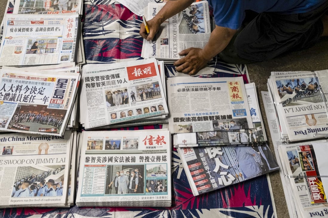 A vendor arranges newspapers for distribution in Hong Kong. Photo: Bloomberg