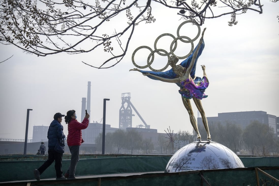 Visitors take photos of a statue of figure skaters with the Olympic rings at a park near the headquarters of the Beijing organising committee for the Olympic Games. Photo: AP