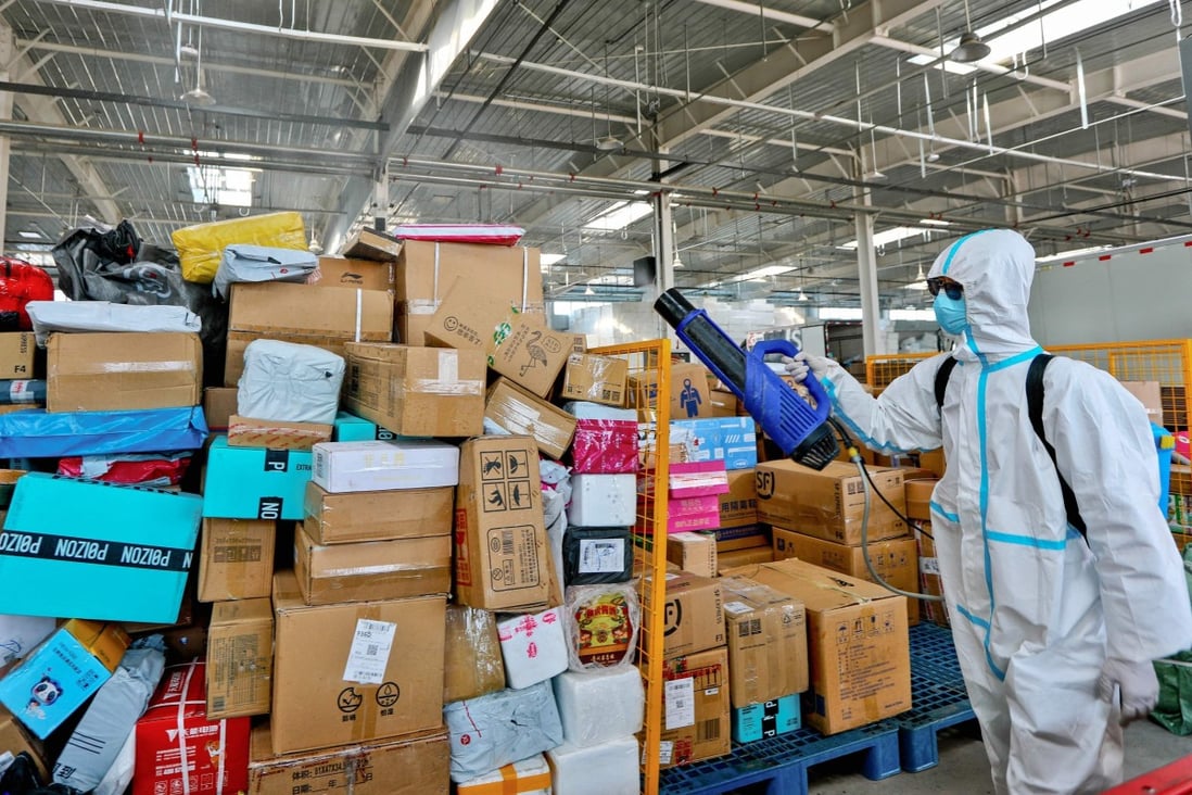 A staff member sprays disinfectant on packages to be delivered as a preventive measure against the Covid-19 coronavirus, at a logistics company in Zhangye, Gansu province. Photo: AFP