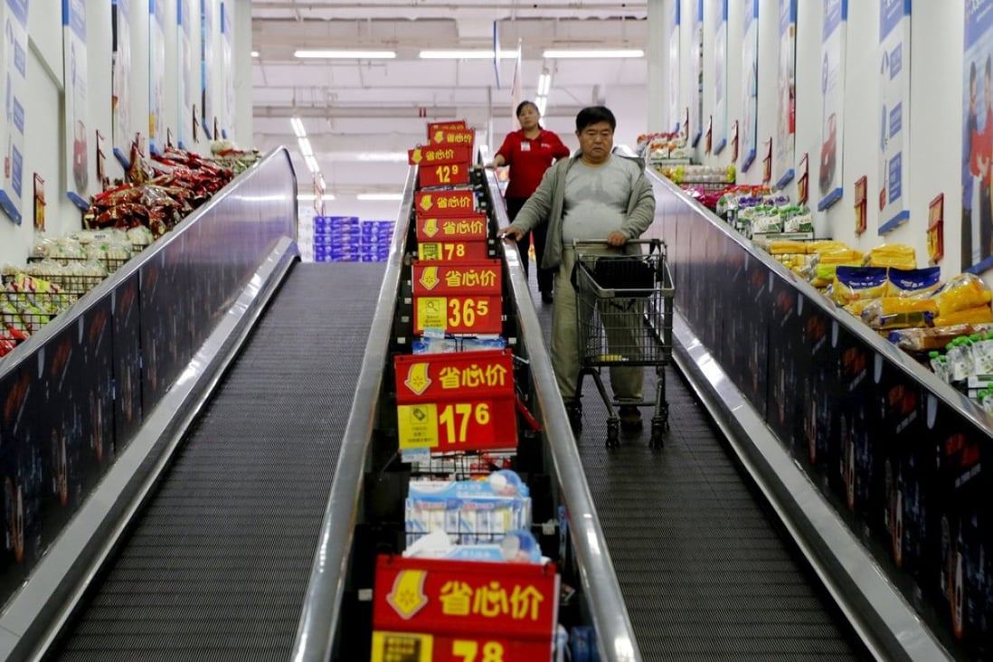 Shoppers ride on a travelator at a supermarket in Beijing, Photo: Reuters