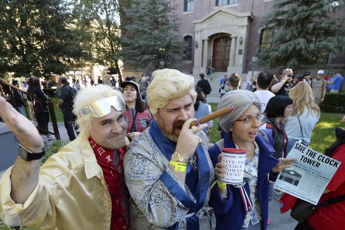 Fans dressed as the characters Dr. Emmett Brown, 1985 rich Biff (C), and as Hill preservation society lady, pose in the Hill Valley Courthouse square in Fillmore, California. Photo: AFP