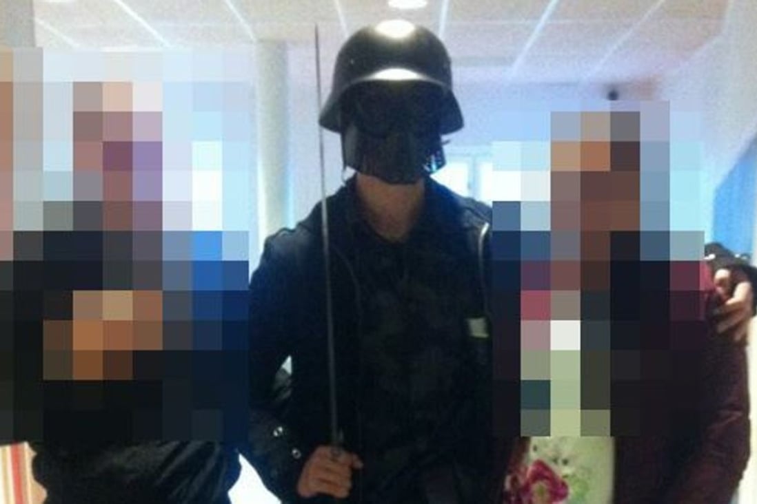 The masked man armed with a sword poses for a photo with two other students before killing two people and wounding two others in Trollhattan, southwestern Sweden. Photo: AFP