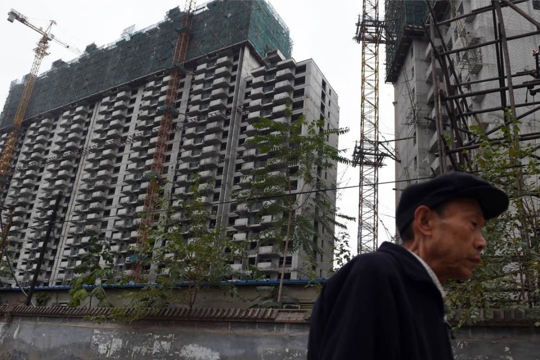 A man walks past a construction site for apartment buildings in Beijing. Photo: AFP