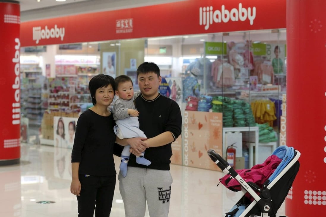 Zhao Xingqiu poses with her husband and baby in front a baby products shop in Beijing last week. Zhao, a 27-year-old office worker, said she does not plan to have a second child. Photo: Reuters