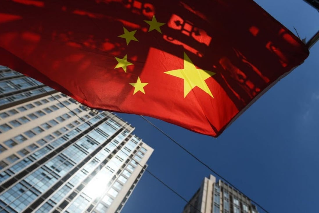 A Chinese flag flies near apartment buildings in Beijing as rising prices cools off sales in the Chinese capital and in Shanghai. Photo: AFP