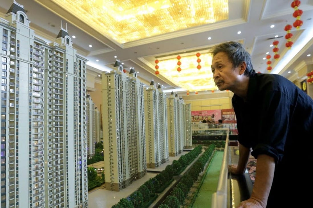 A visitor looks at a model of a new apartment complex at a showroom of Evergrande Real Estate Group in Wuhan, Hubei province, China. Photo: Reuters