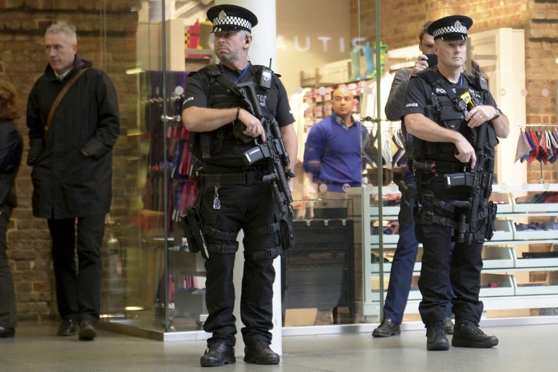 Armed police at the Eurostar terminal in London observe a minute of silence in honour of the victims of the Paris attacks. Security has also been stepped up outside the French embassy. Photo: AP