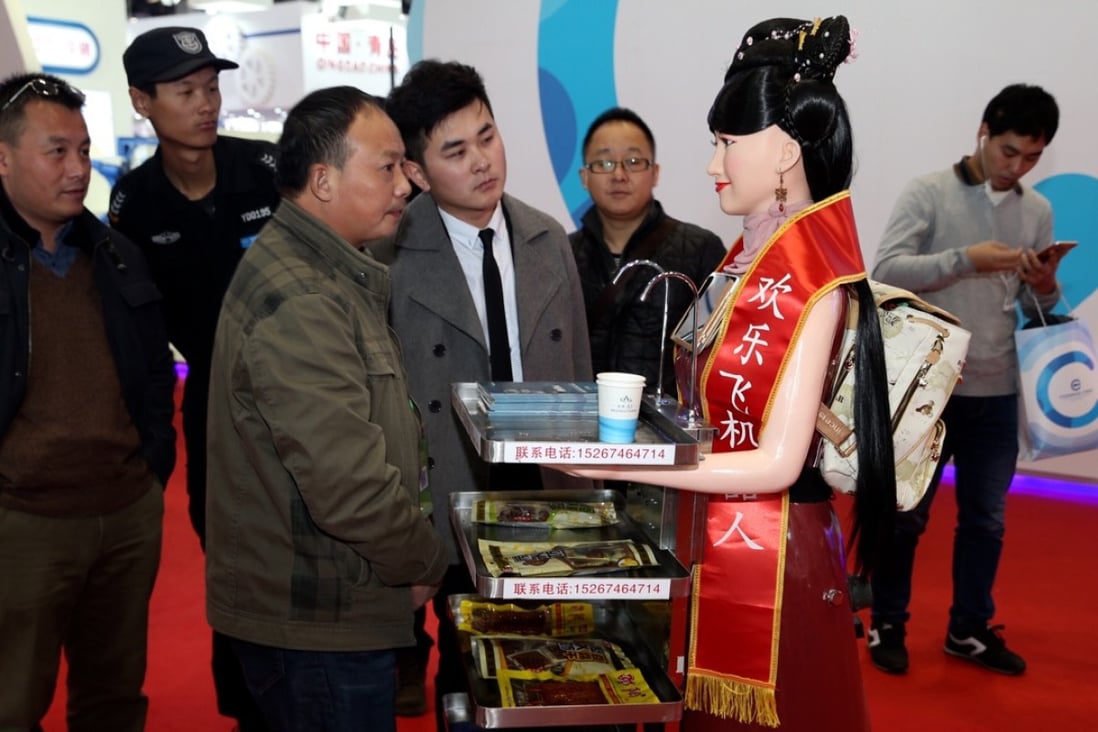 Visitors interact with a robot that can serve as a waitress during the World Robot Conference in Beijing. Photo: Xinhua