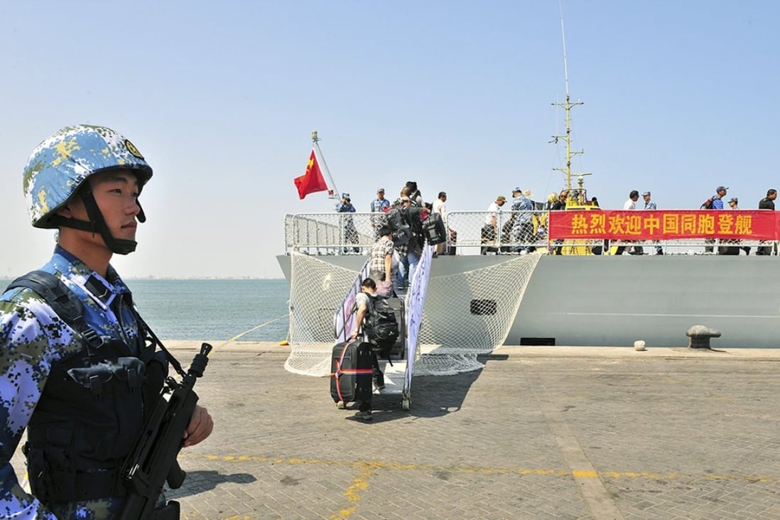 A navy soldier of People's Liberation Army (PLA) stands guard as Chinese citizens board the naval ship "Linyi" at a port in Aden. Photo: Reuters