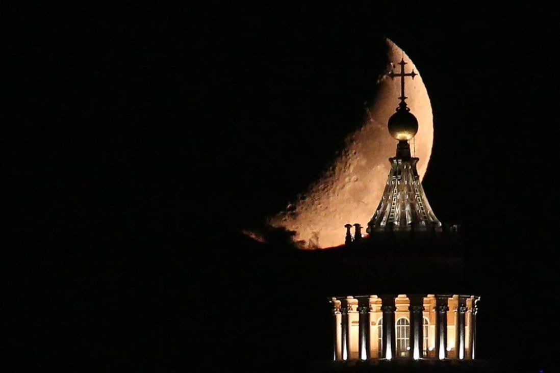 The moon seen behind Saint Peter’s Basilica in Rome. Photo: EPA