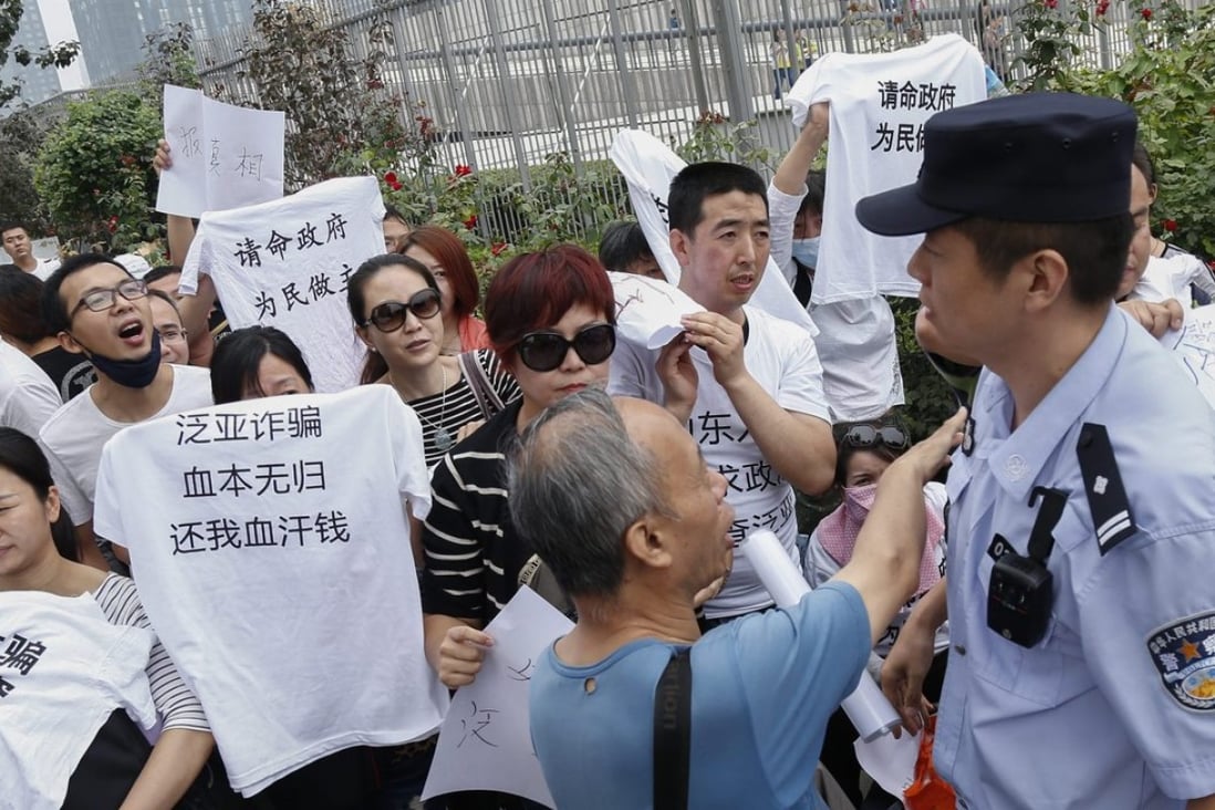 Protesters argue with a Chinese policeman (right) as they stage a demonstration in Beijing in September against Fanya Metal Exchange. File photo EPA