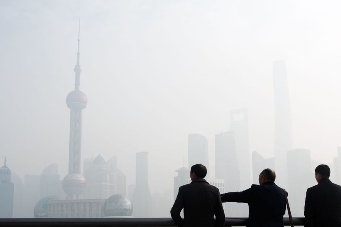 Men stand along the Bund in front of the financial district of Pudong in Shanghai on Tuesday. Photo: AFP