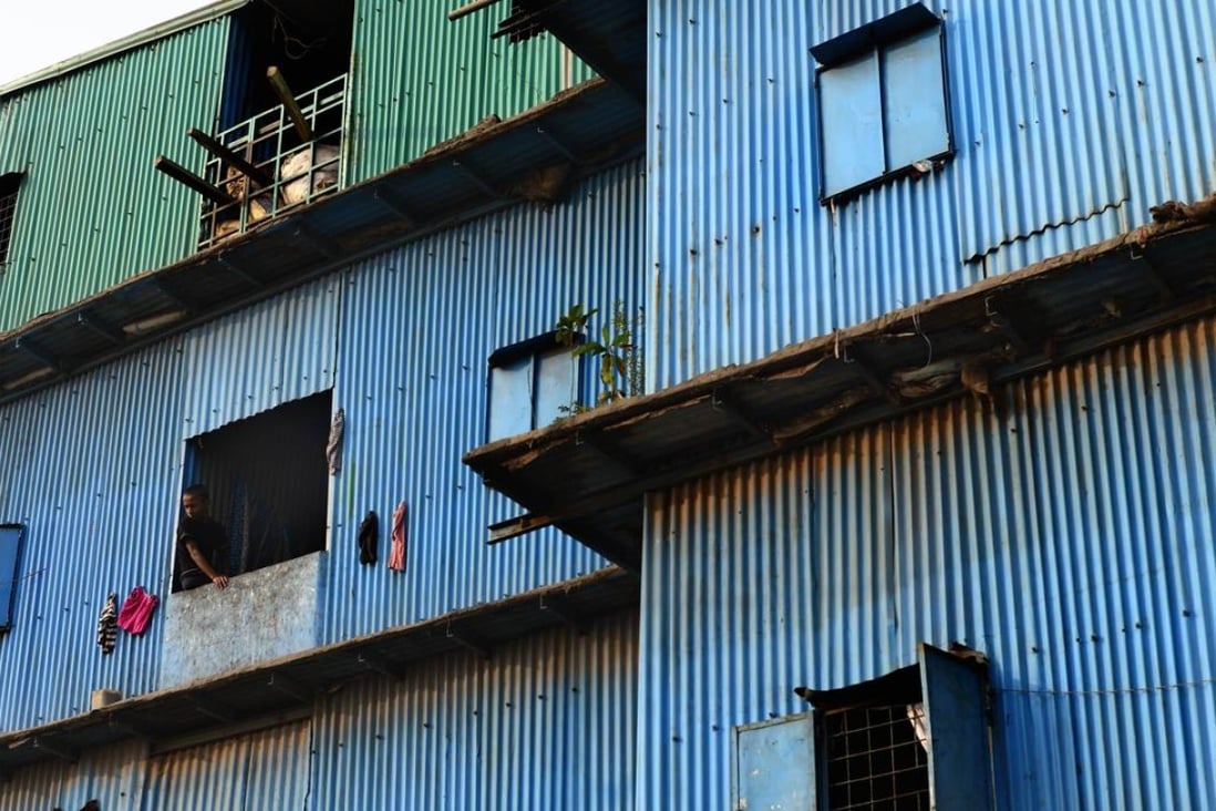 A Bangladeshi youth looks out from a slum house near the Buriganga river in Dhaka. Photo: AFP