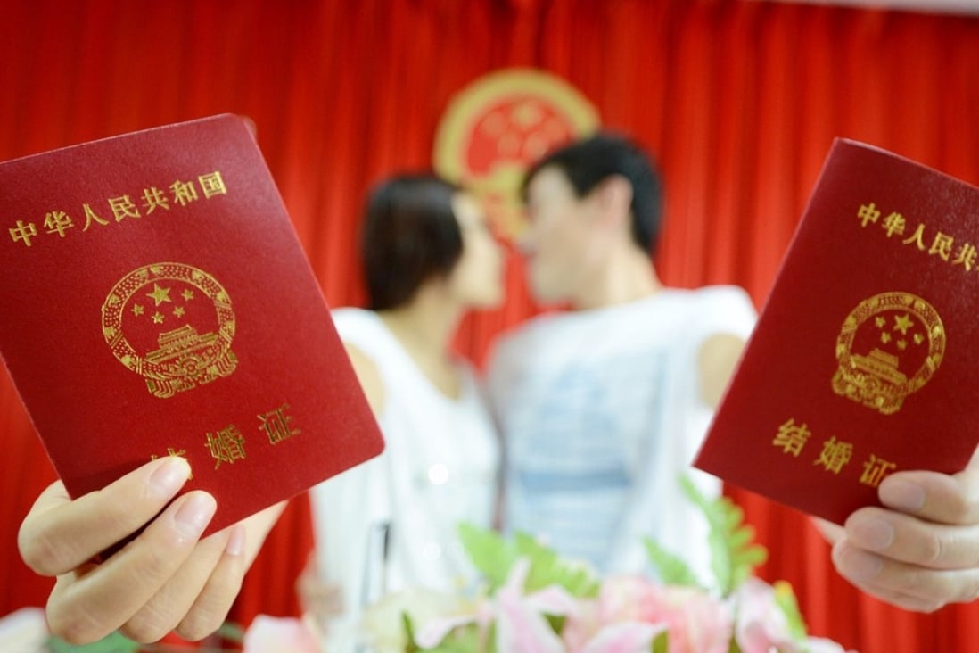 A young couple show off their marriage certificates after registering their union in Yangzhou, Jiangsu province. Photo: China Foto Press