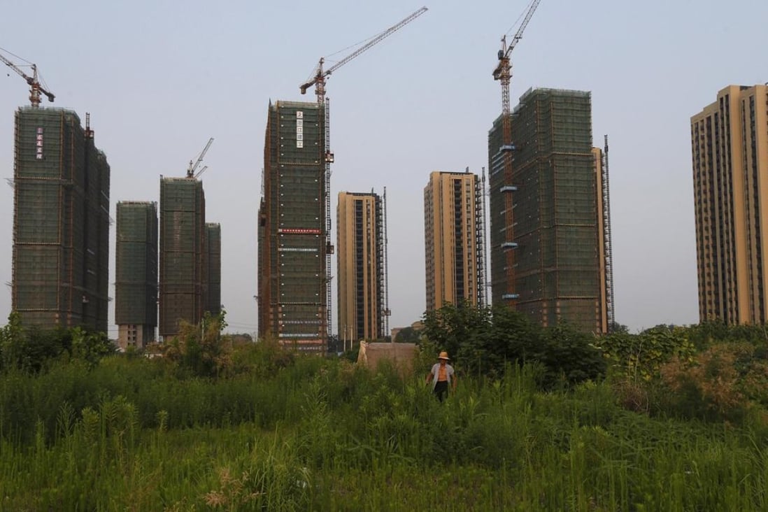A farmer walks in front of a construction site of new residential buildings in Hangzhou, Zhejiang province. Photo: Reuters