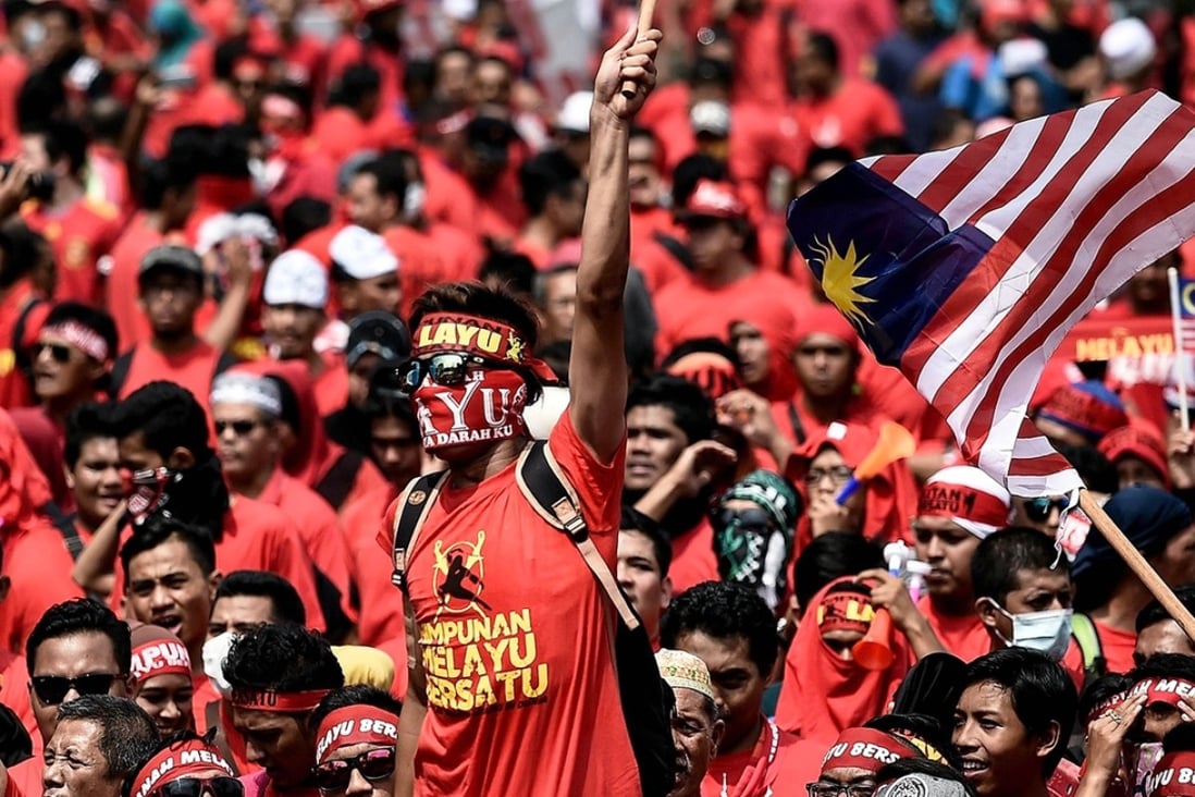 Pro-government ethnic Malay hardliners wave flags and shout slogans during a “red shirt” demonstration in Kuala Lumpur, Malaysia, on September 16. The overtly anti-Chinese rally drew concern from China’s ambassador. Photo: AFP