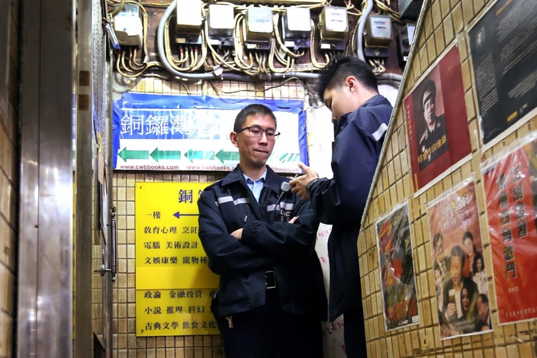 Police officers check the locked front door of Causeway Bay Books in Lockhart Road, Causeway Bay. Photo: Felix Wong