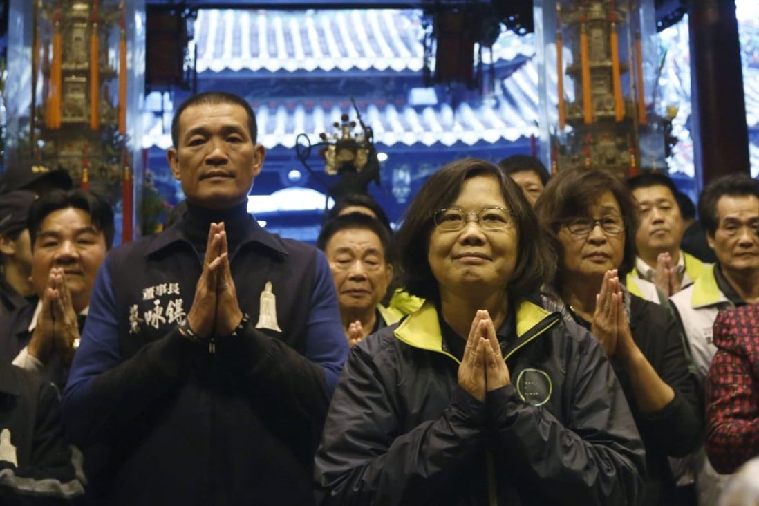 Taiwan's Democratic Progressive Party presidential candidate Tsai Ing-wen (centre) prays at a temple during a campaign stop in Beigang, Taiwan. Photo: Reuters