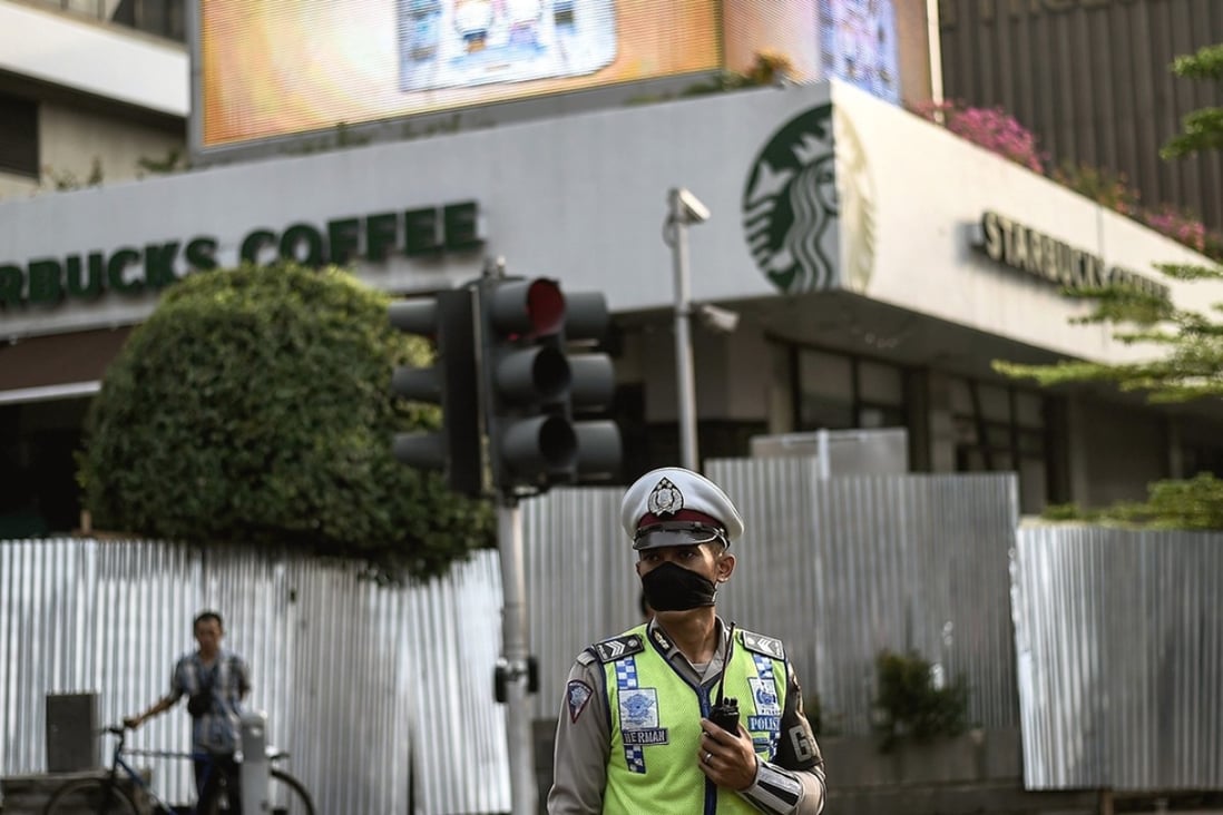 Explosions ripped through this Central Jakarta Starbucks leaving it a ruin yesterday. It was boarded up morning as police arrested three people over the terror attacks. Photo: AFP