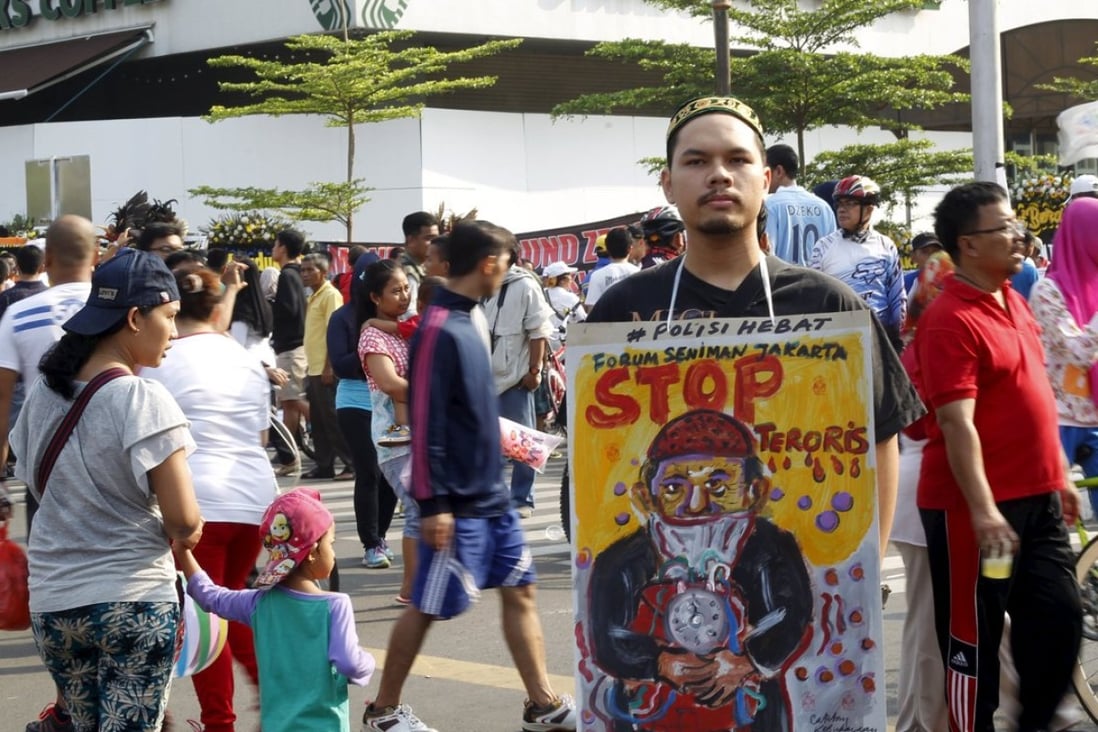 A man holds a placard that reads "Stop terrorists" in Jakarta. Photo: Reuters