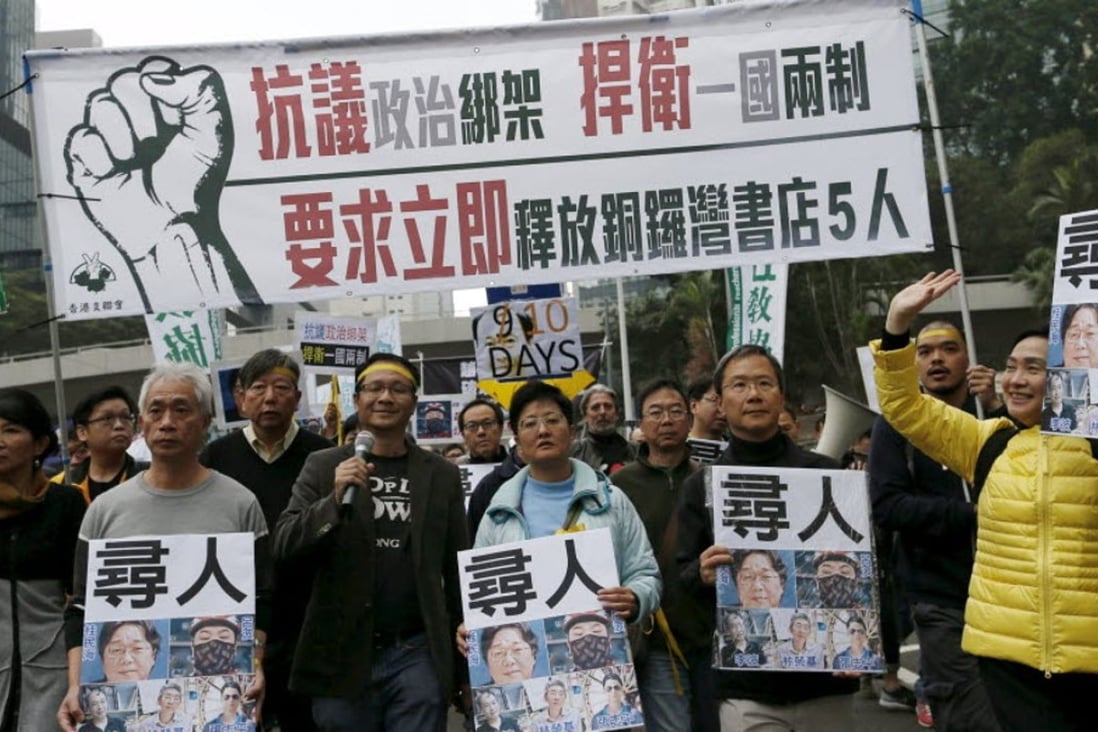Demonstrators hold up portraits of five missing staff members of a publishing house and a bookstore during a protest over the disappearance of the booksellers. Photo: Reuters