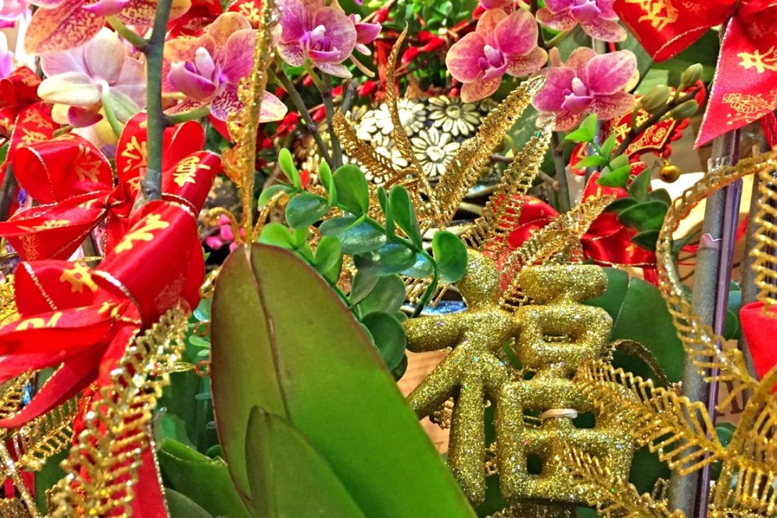Decorating orchids with “luck” for Lunar New Year. Photo: Laura Ma