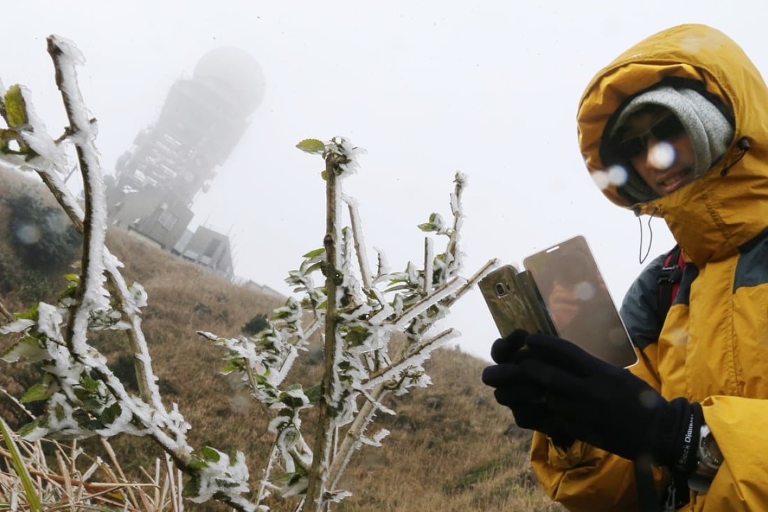 A visitor captures the ice on Tai Mo Shan yesterday as the Hong Kong Observatory issued a frost warning. Photo: Dickson Lee