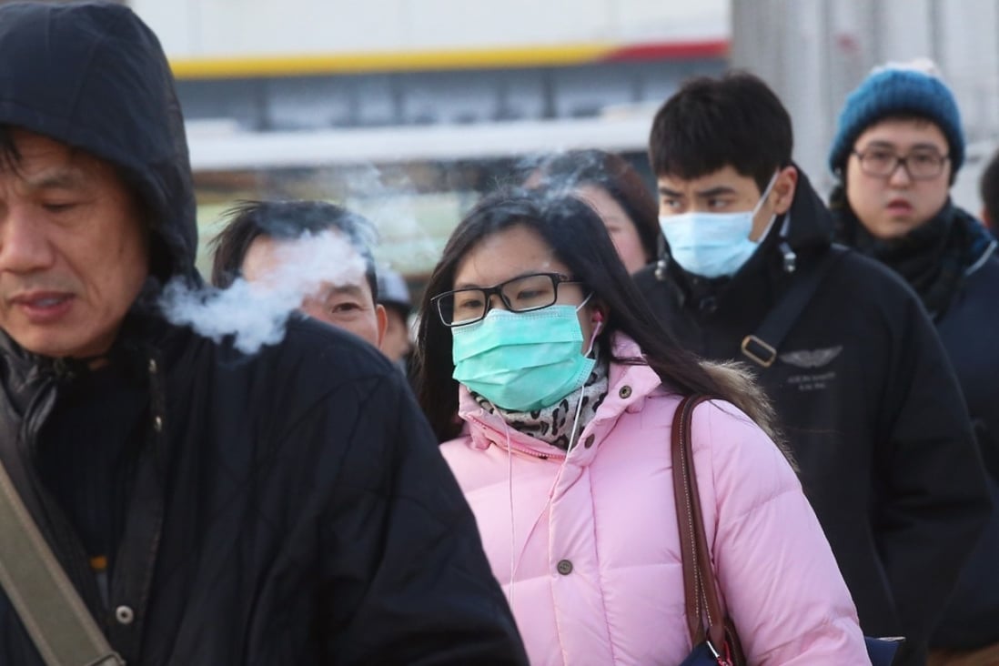 People wearing masks and thick clothes on the coldest Monday of the city in 59 years. Photo: K.Y. Cheng