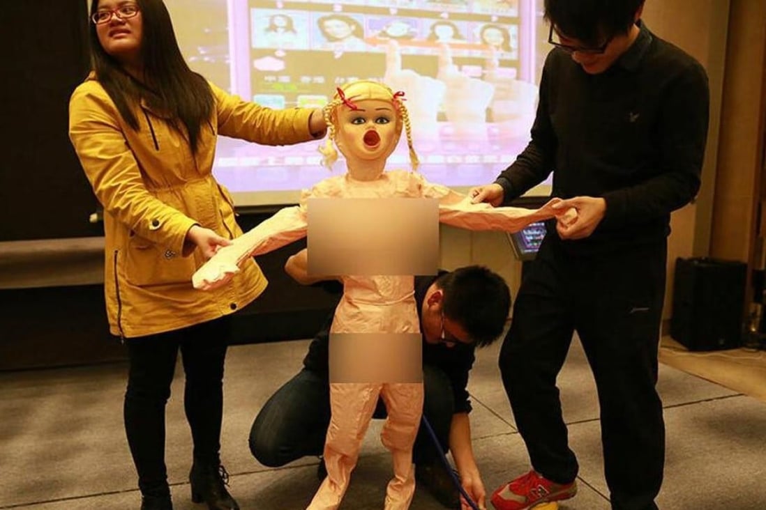 Staff at Chinese internet firm Lianlian are told how to use an inflatable sex doll, given to young men working for the company instead of a tradition cash bonus, at Sunday’s company annual conference. Photo: Guangming Daily