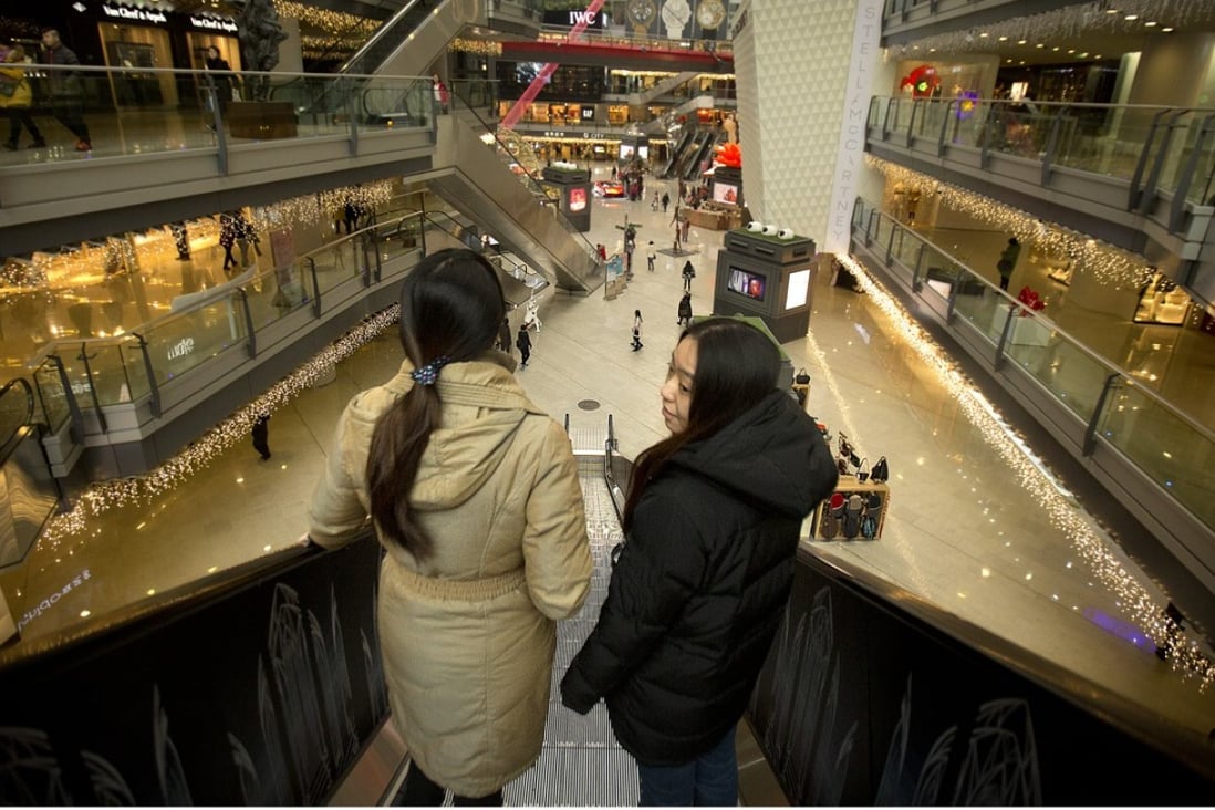 People ride an escalator in an upmarket shopping mall in Beijing. Photo: AP