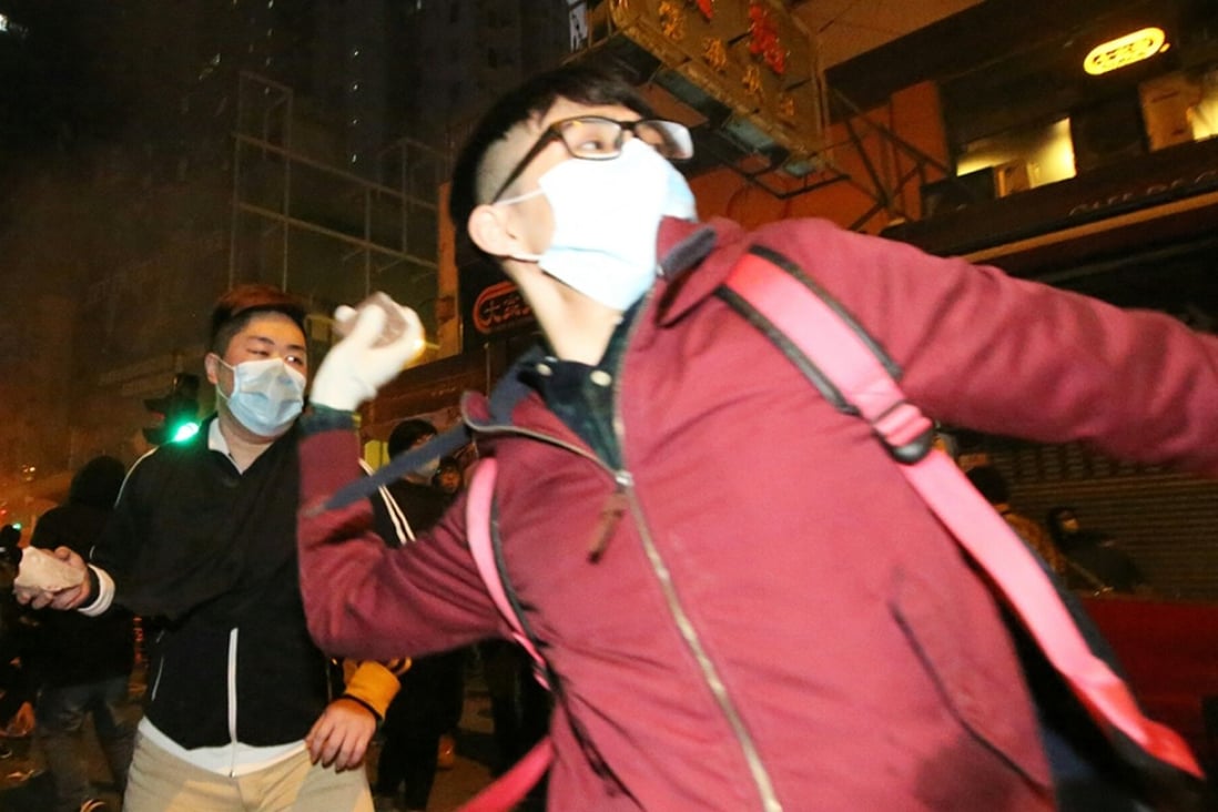 Protesters throw bricks as police try to disperse the crowd during the riot in Mong Kok. Photo: Edward Wong
