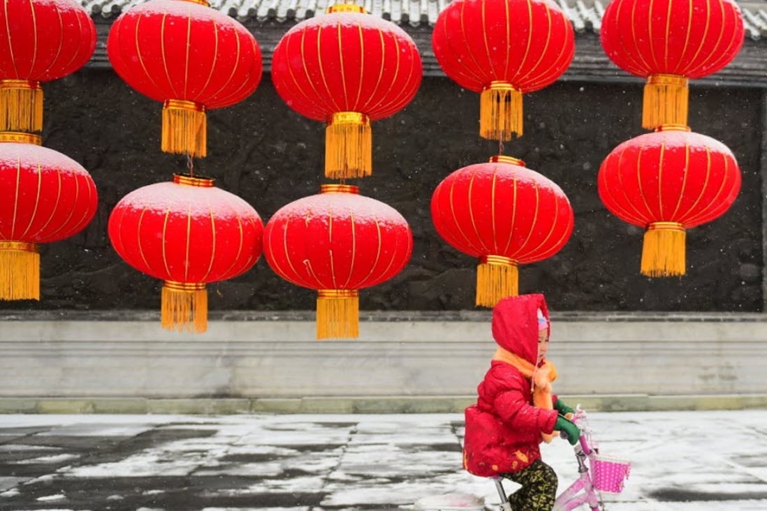 A girl rides her bike past giant lanterns in Changchun, northeast China’s Jilin Province. Photo: Xinhua/Lin Hong