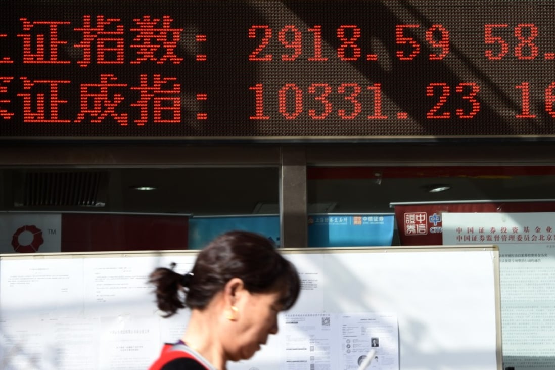 A woman walks by in front of an electronic stock indicator of a securities firm in Beijing, capital on February 22. Photo: Xinhua