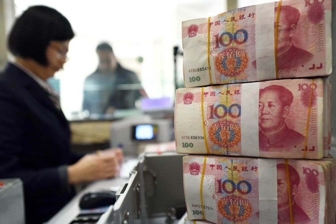 An employee counts 100-yuan notes at a bank in Lianyungang, Jiangsu province. Photo: AFP