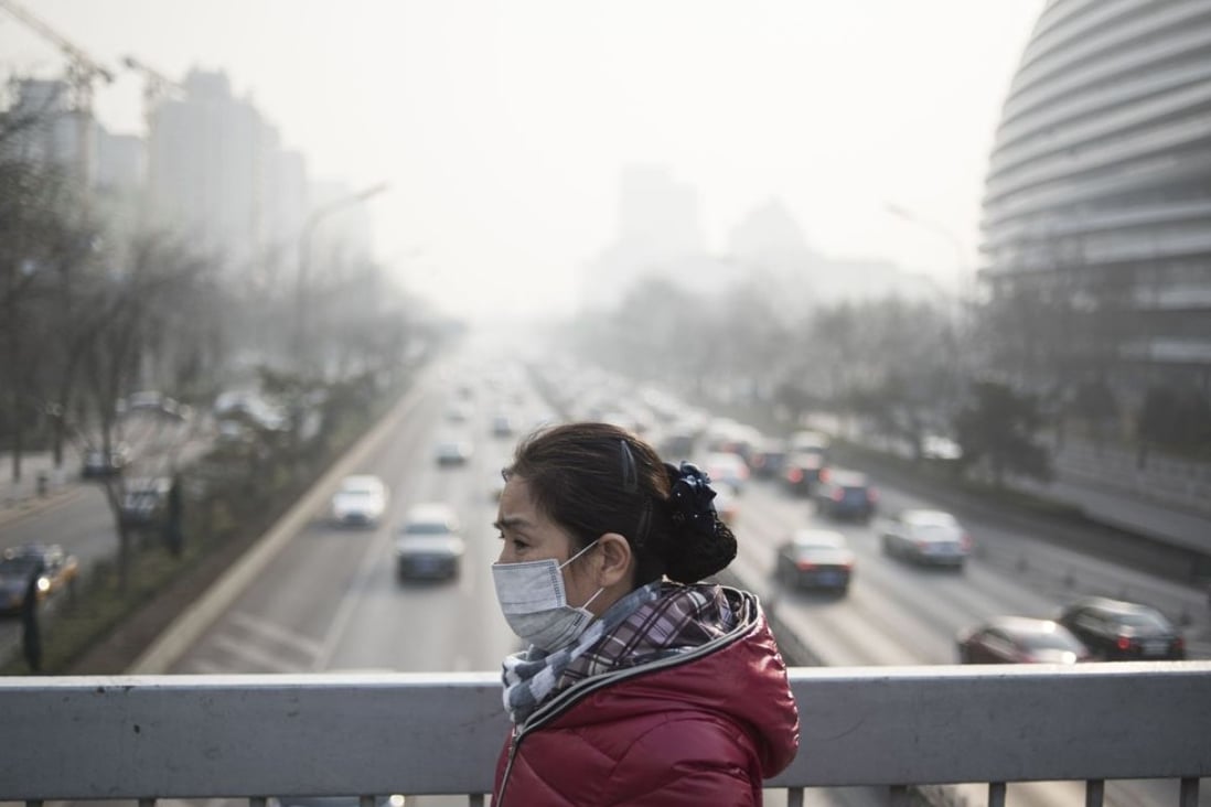 A pedestrian in Beijing during last December’s red smog alert. The environmental ministry created a total emission control department in 2010 to ensure targets were met, but the approach has been criticised as ineffective. Photo: AFP