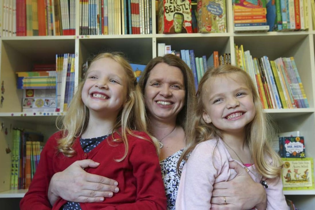 Sara Young at home in Pok Fu Lam with her two daughters Sophie (left), 8, and Jessica (right), 5. Photo: Edward Wong