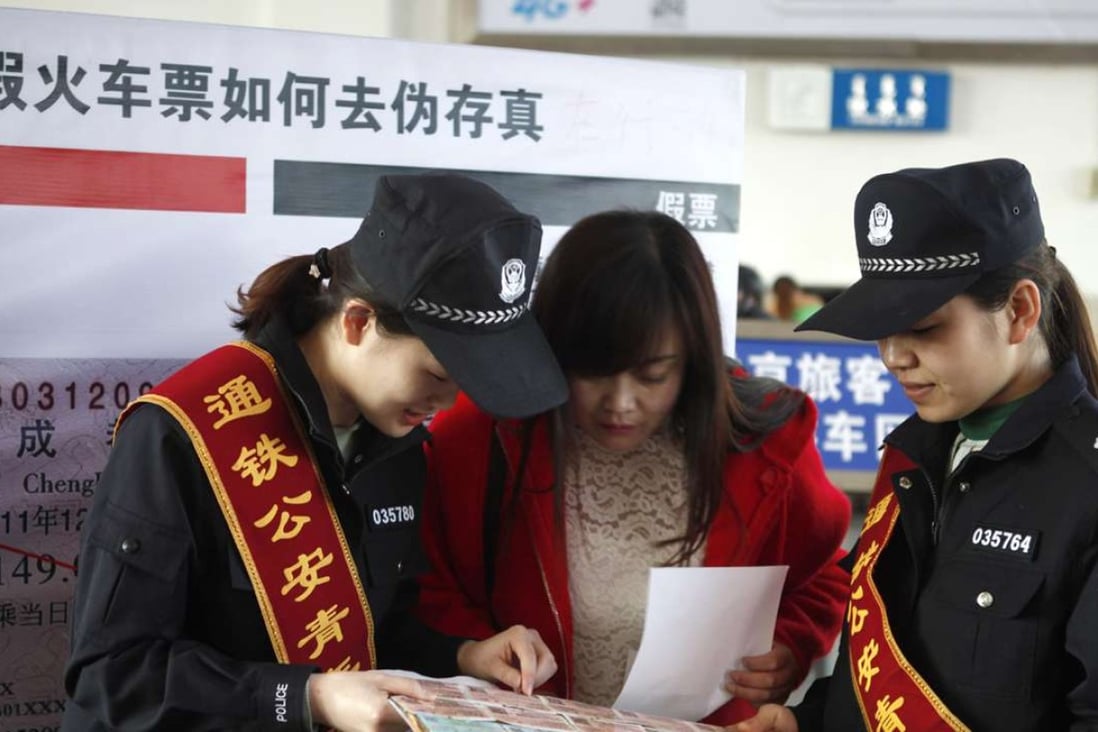 Railway police in Inner Mongolia show a passenger how to spot fake rail tickets on World Consumer Rights Day on Tuesday. Photo: Xinhua