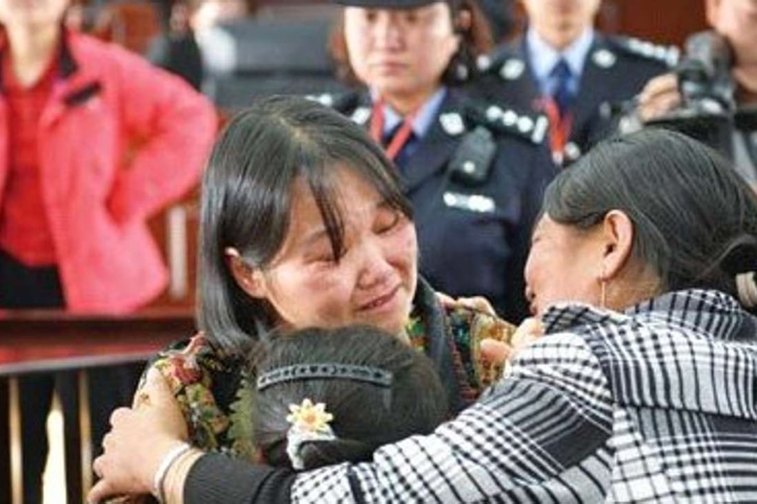 Zhang, facing camera, is embraced by her daughter and a family member in court.