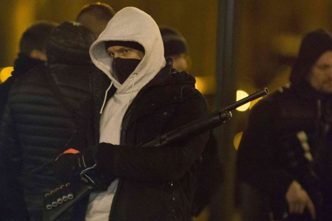 Police officers stand guard outside a building during a raid in the Argenteuil neighbourhood northwest of Paris. A suspect was taken away. Photo: AFP