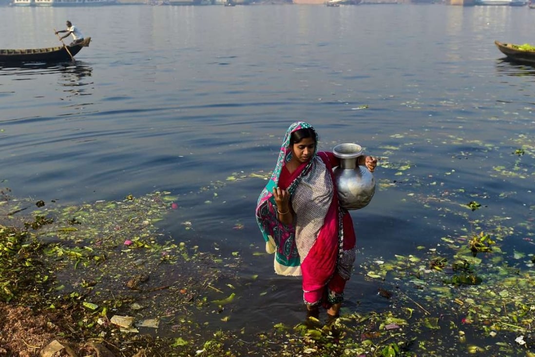 A Bangladeshi woman collects contaminated water from the polluted Buriganga in Dhaka. Photo: AFP