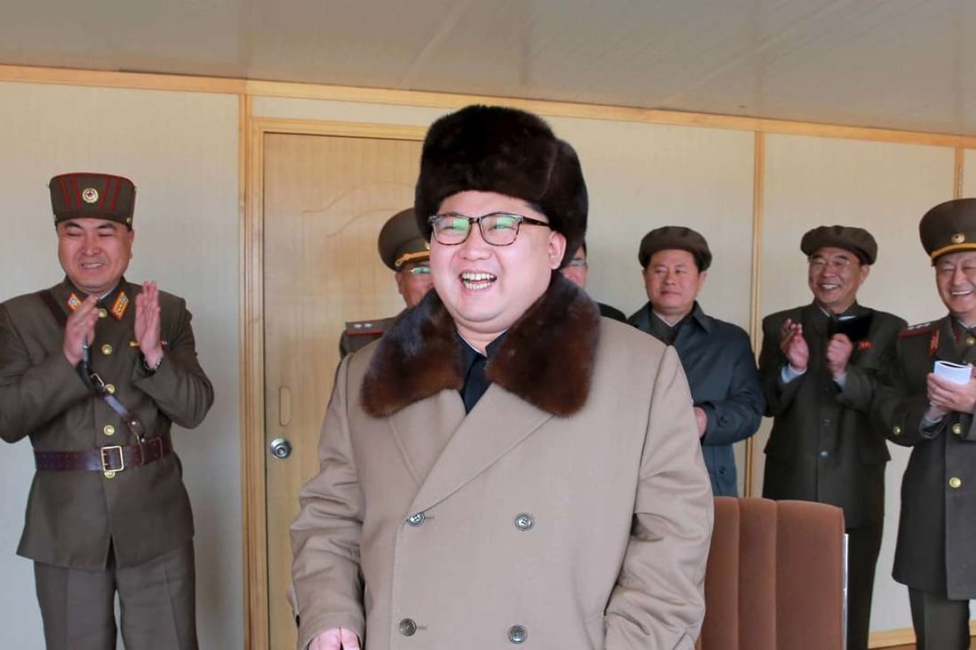 North Korean leader Kim Jong-un (centre) smiles as he watches the testing of a new guided anti-air missile weapon system in a photograph issued on April 2. Photo: Reuters/KCNA