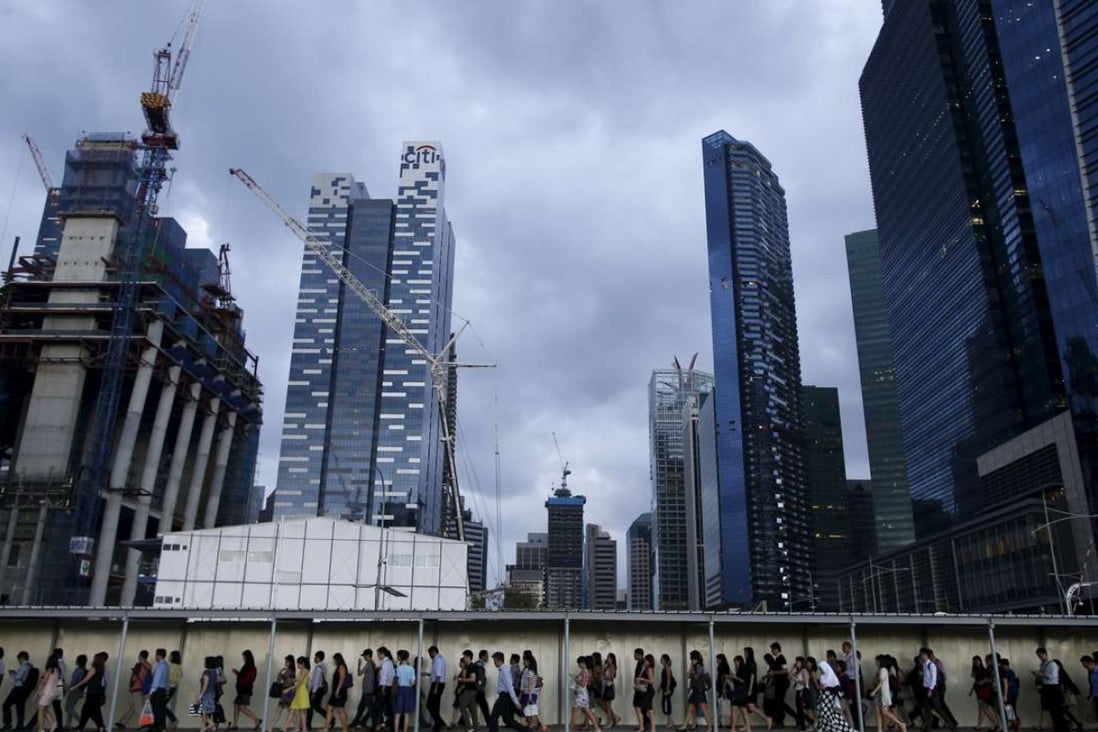 Office workers walk to the train station during evening rush hour in the financial district of Singapore. Photo: Reuters