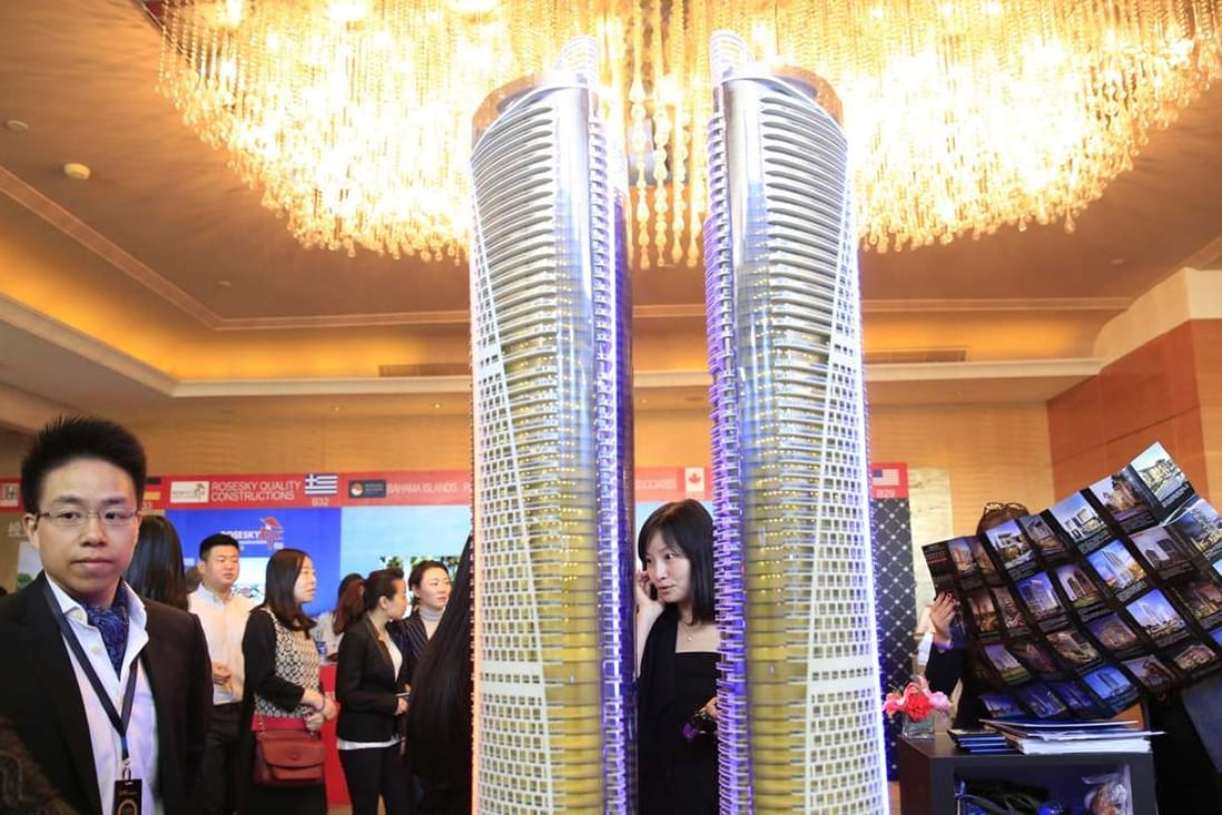 Visitors look at a luxury property model on display during the Luxury Property Showcase in Beijing on April 22, 2016. Photo: EPA