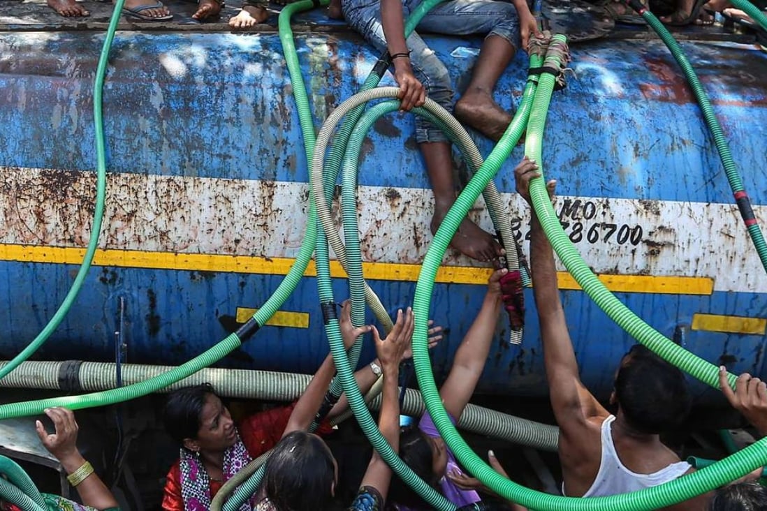 People collect water from a water tanker. Photo: EPA