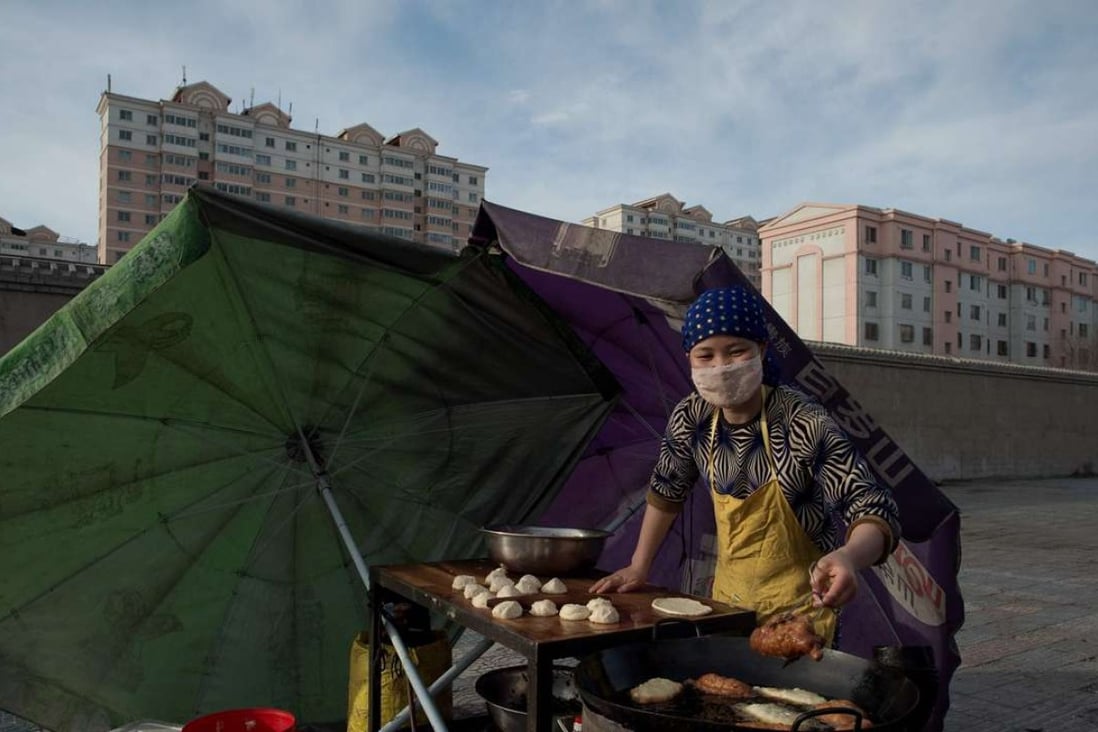 A street food vendor cooks food nearby the Jiuquan Iron & Steel (Group) factory complex as the sun rises over the city of Jiayuguan, some 2,000 km (1,250 miles) west of Beijing on April 22, 2016. Photo: AFP