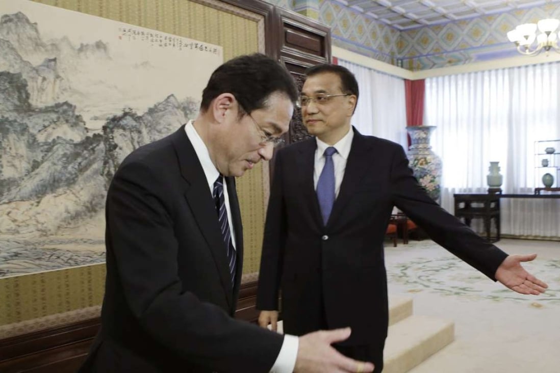 China's Premier Li Keqiang, right, directs Japanese Foreign Minister Fumio Kishida to a meeting at the Zhongnanhai leadership compound in Beijing on Saturday. Photo: AP)