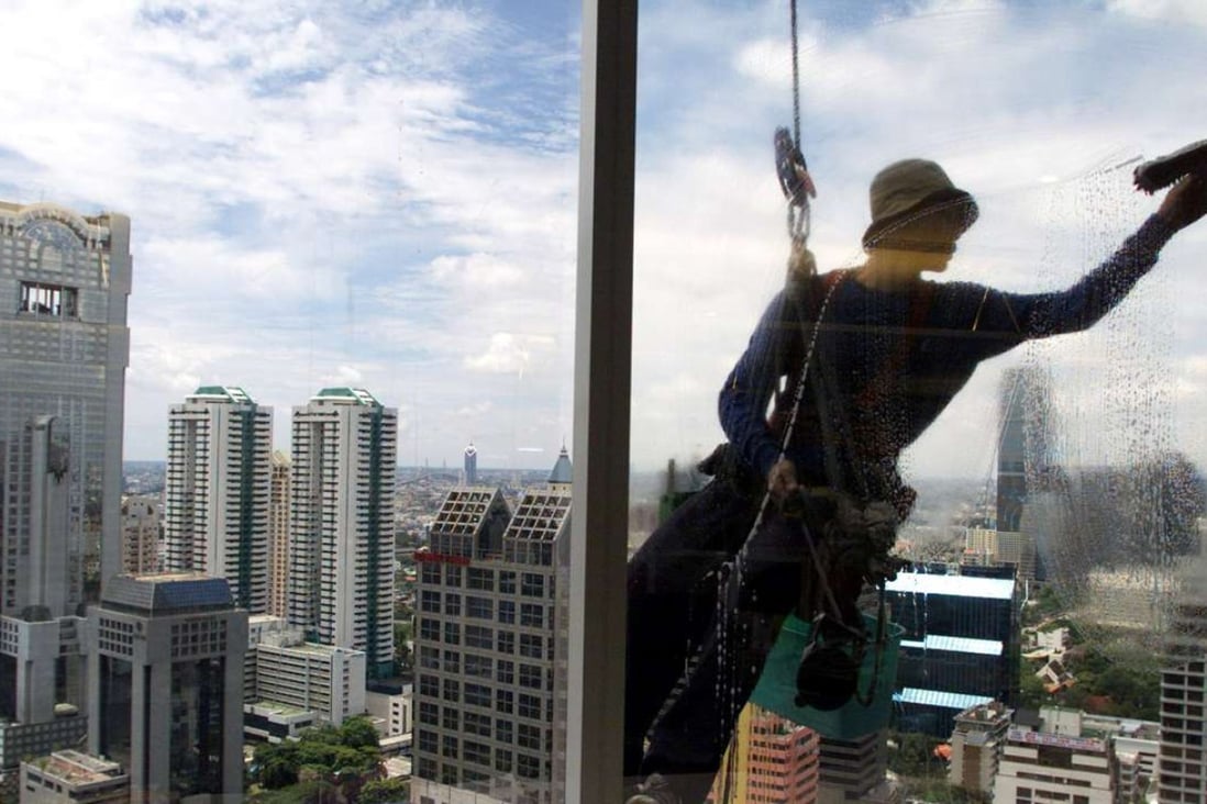 A Thai window cleaner hangs by a rope as he goes to work high above the Bangkok business district of condominiums and office buildings. Reuters