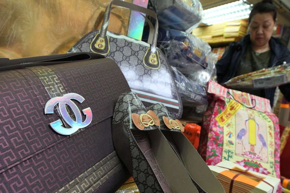 A shopper peruses paper luxury accessories sold as tributes for the departed at a Hong Kong store. Photos: Felix Wong
